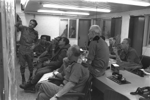 דיון צבאי בחדר המלחמה בפיקוד דרום, 8 באוקטובר 1973. בשורה הראשונה שלישי מימין הרמטכ"ל דוד אלעזר, לשמאלו אלוף פיקוד דרום שמואל גונן (גורודיש). מאחור: ראשון מימין הרמטכ"ל לשעבר יצחק רבין. צילם: שלמה ארד, לשכת העיתונות הממשלתית